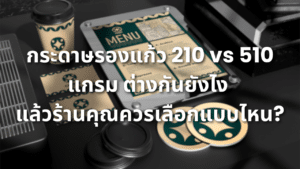 กระดาษรองแก้วพิมพ์โลโก้สีเขียวทองวางบนโต๊ะสีเข้ม พร้อมแก้วกระดาษและเมนูร้านกาแฟ สำหรับเปรียบเทียบกระดาษรองแก้ว 210 และ 510 แกรม